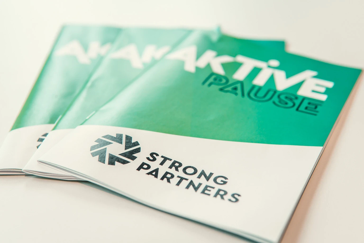 Informationsmaterial zur Aktiven Pause von Strong Partners, mit Broschüren zur betrieblichen Gesundheitsförderung und Be
