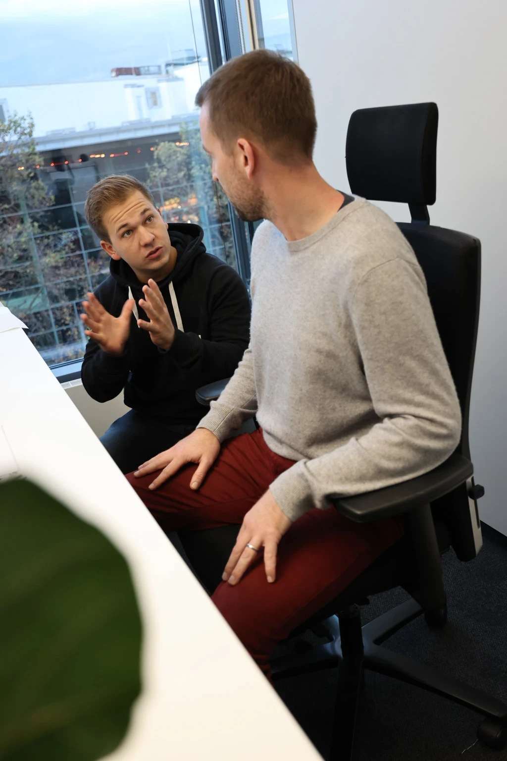 Mitarbeiter zeigt einem Teilnehmer die richtige Sitzposition im Rahmen eines Ergonomieworkshops
