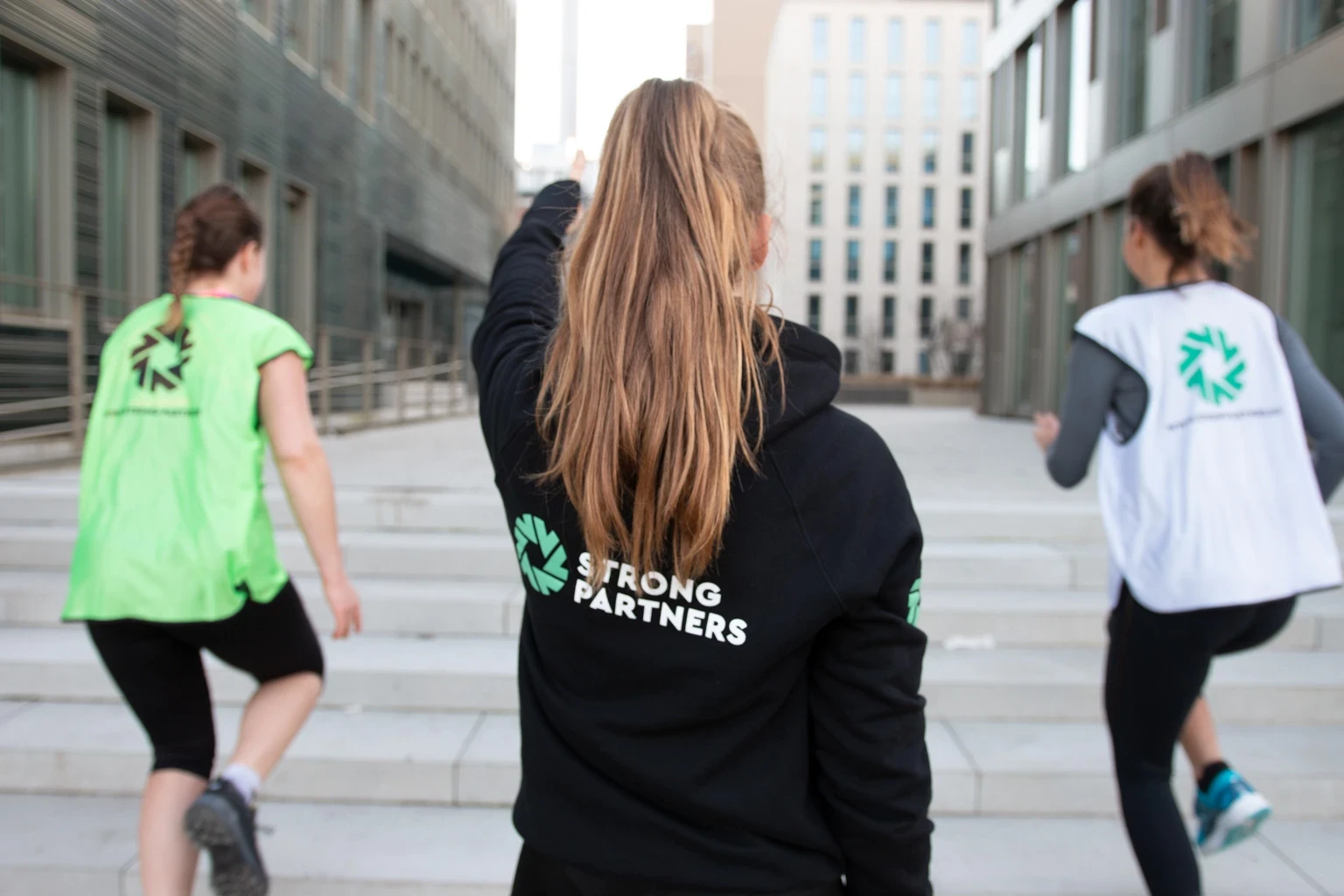 Teilnehmende eines Firmenfitness-Kurses durchgeführt von Strong Partnersmotivieren sich gegenseitig