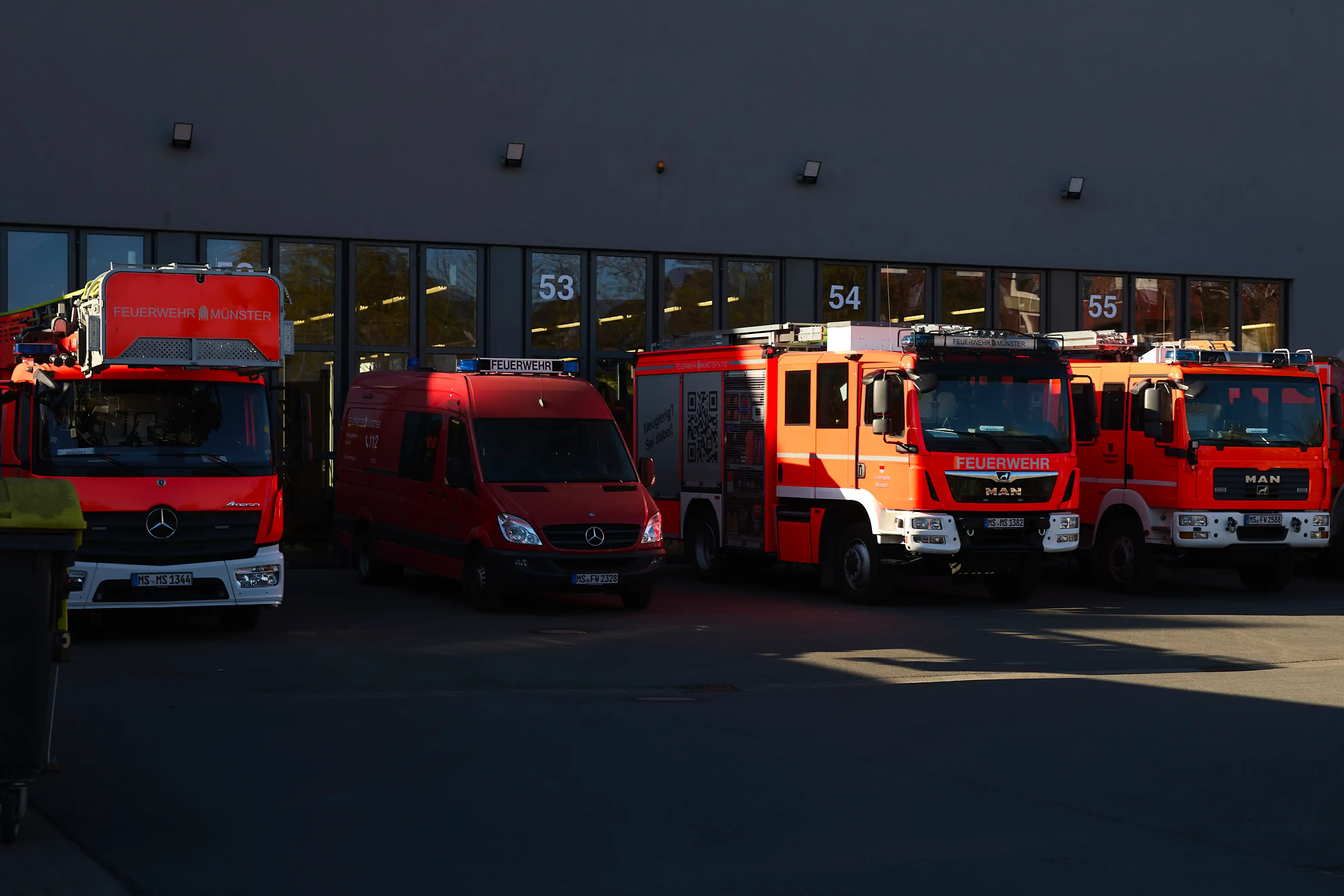 Einsatzkraft-Fahrzeuge in der Reihe an einer Wache stehend