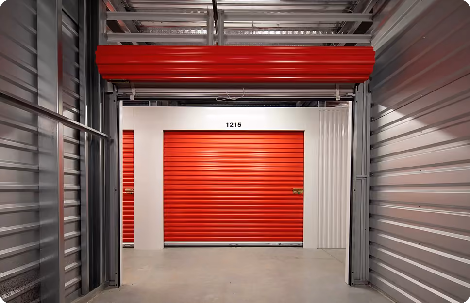 Indoor Stack N Stor, interior view of a self-storage facility with red roll-up doors, including one labeled 1215.