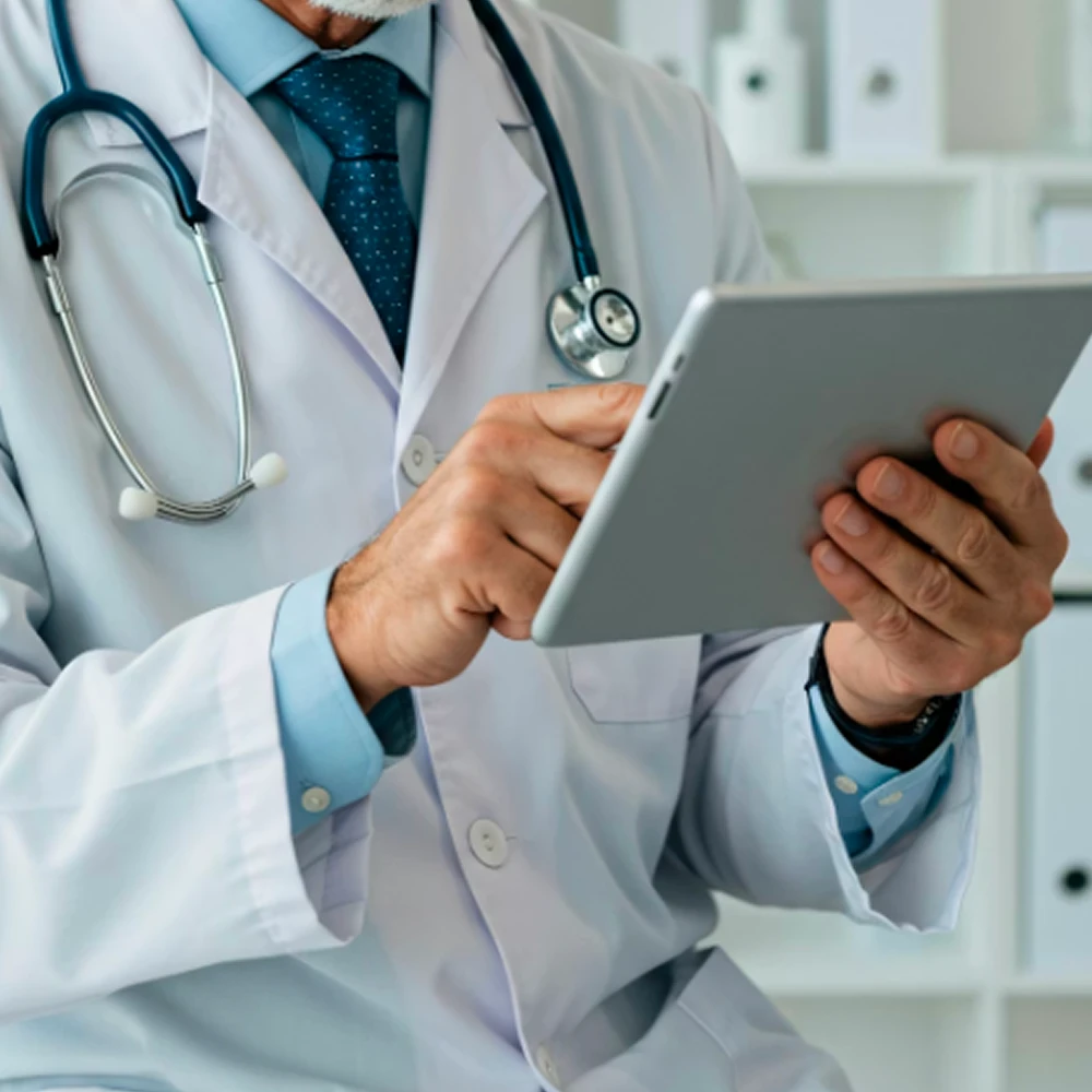 Médecin utilisant une tablette pour illustrer les solutions de santé digitale.
