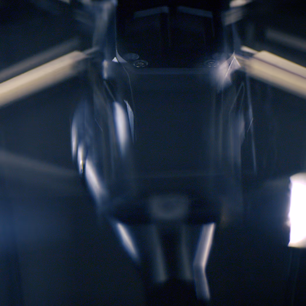 Close-up of a microscope lens with blurred reflections and dark background.