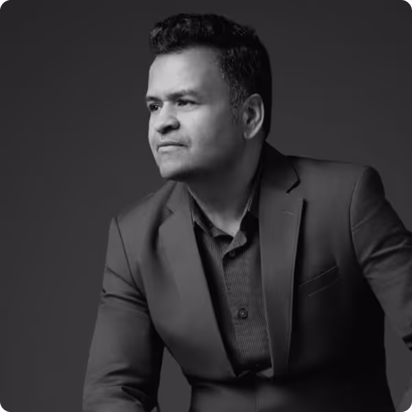 Black-and-white portrait of a man in a blazer looking thoughtfully to the left.