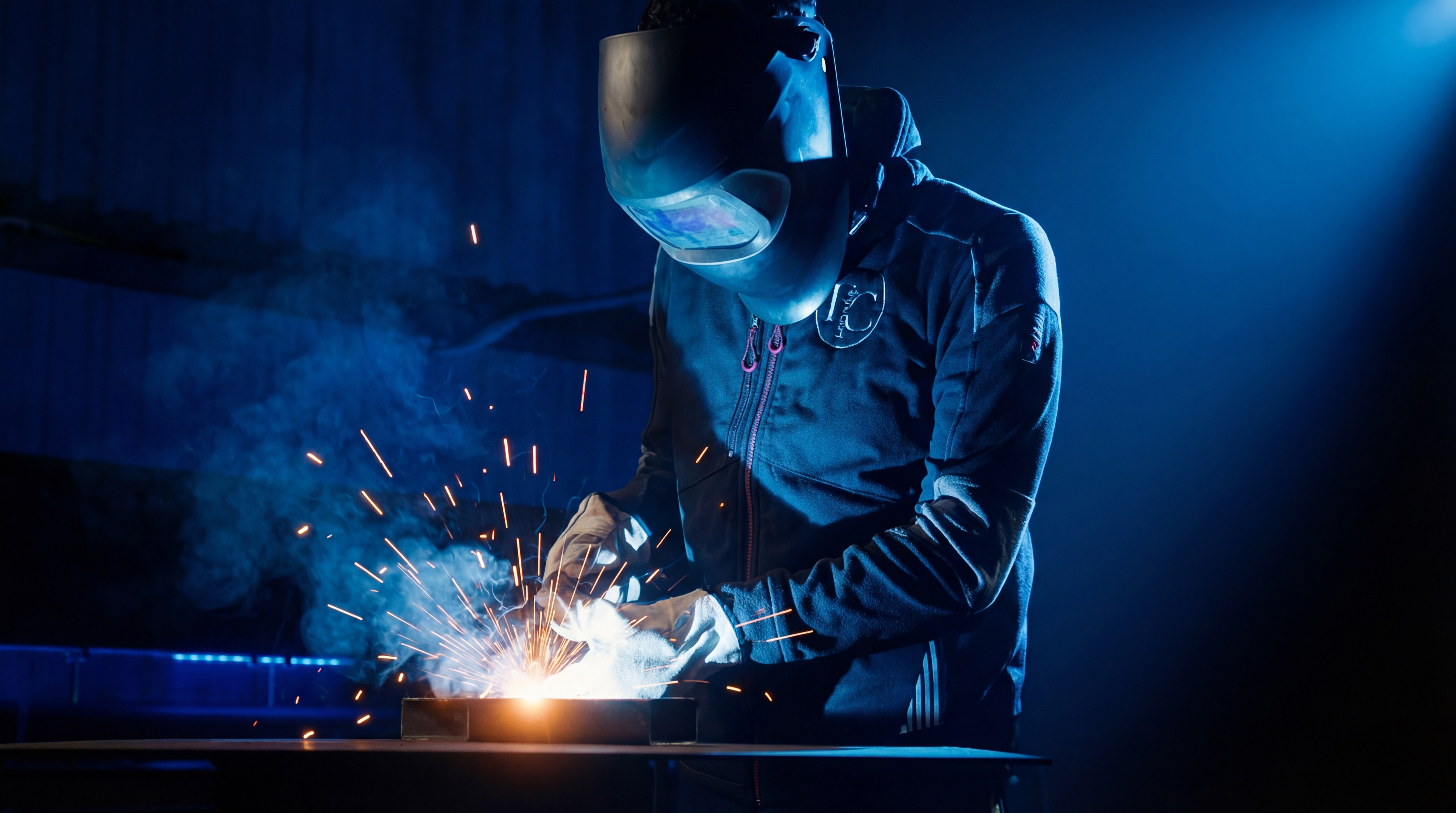 Un technicien découpe et soude des pièces pour assembler la machine