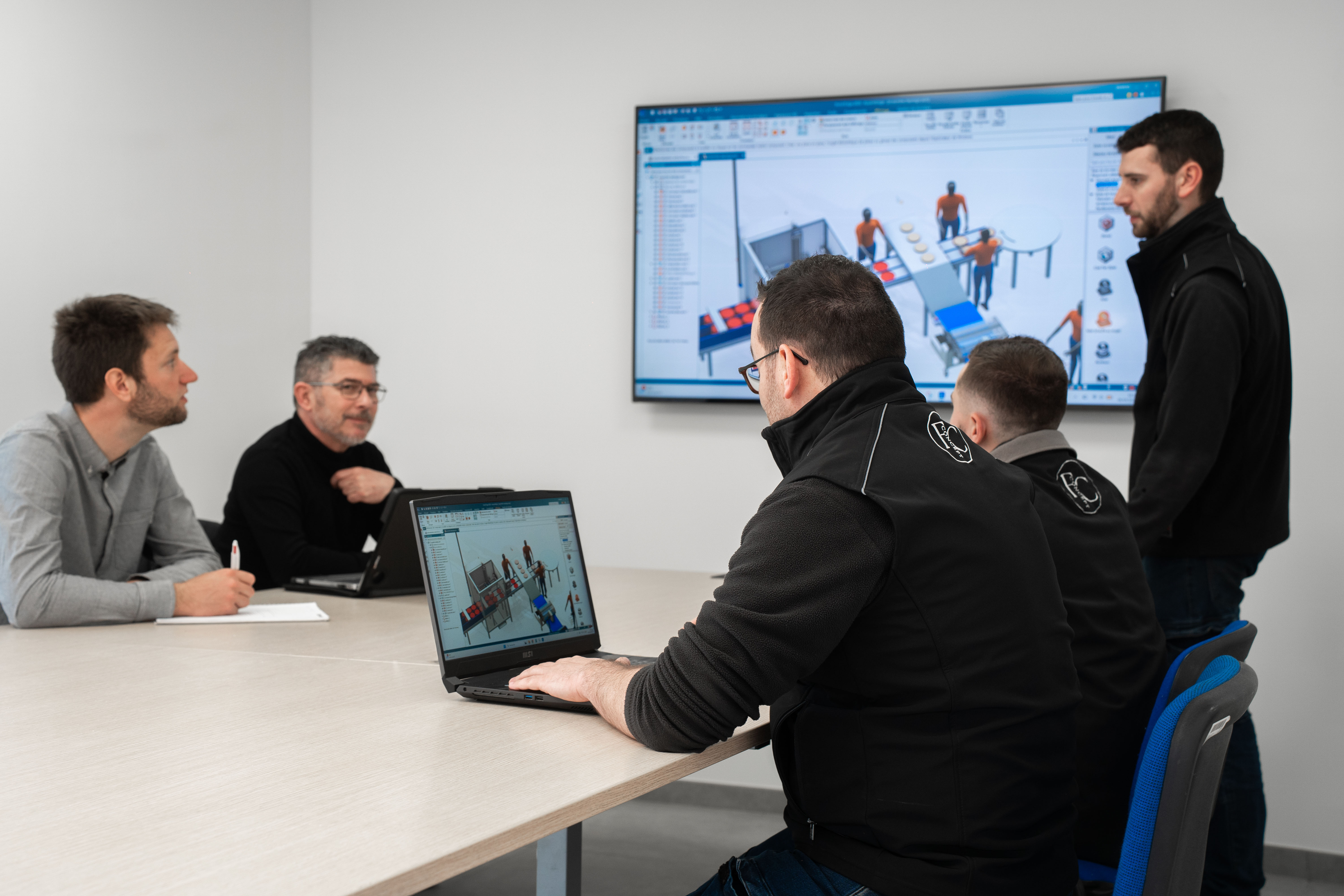 Les membres de l'équipe et le client échangent en réunion autour d'une table