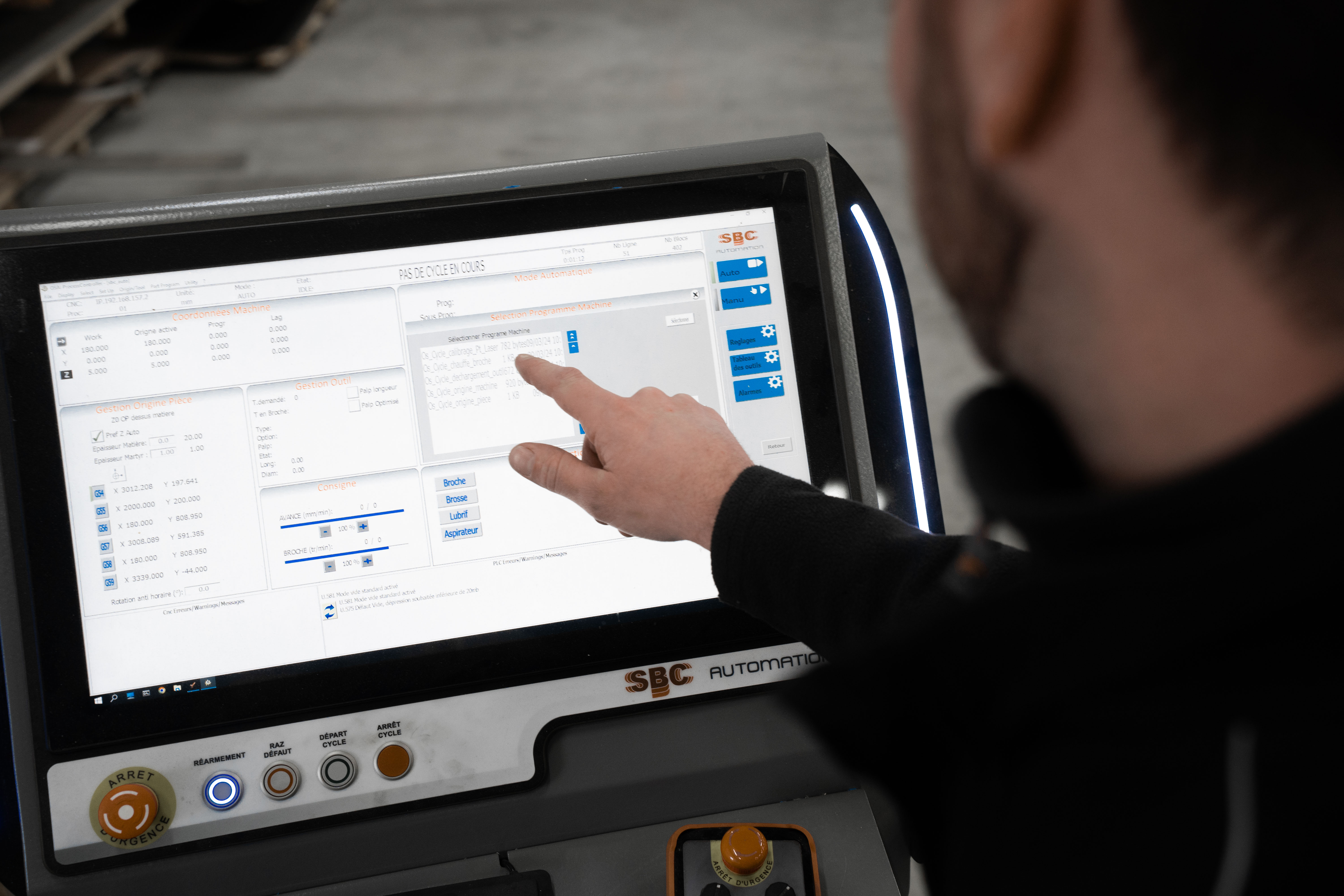 Un opérateur réalise des essais et paramètre une machine de découpe