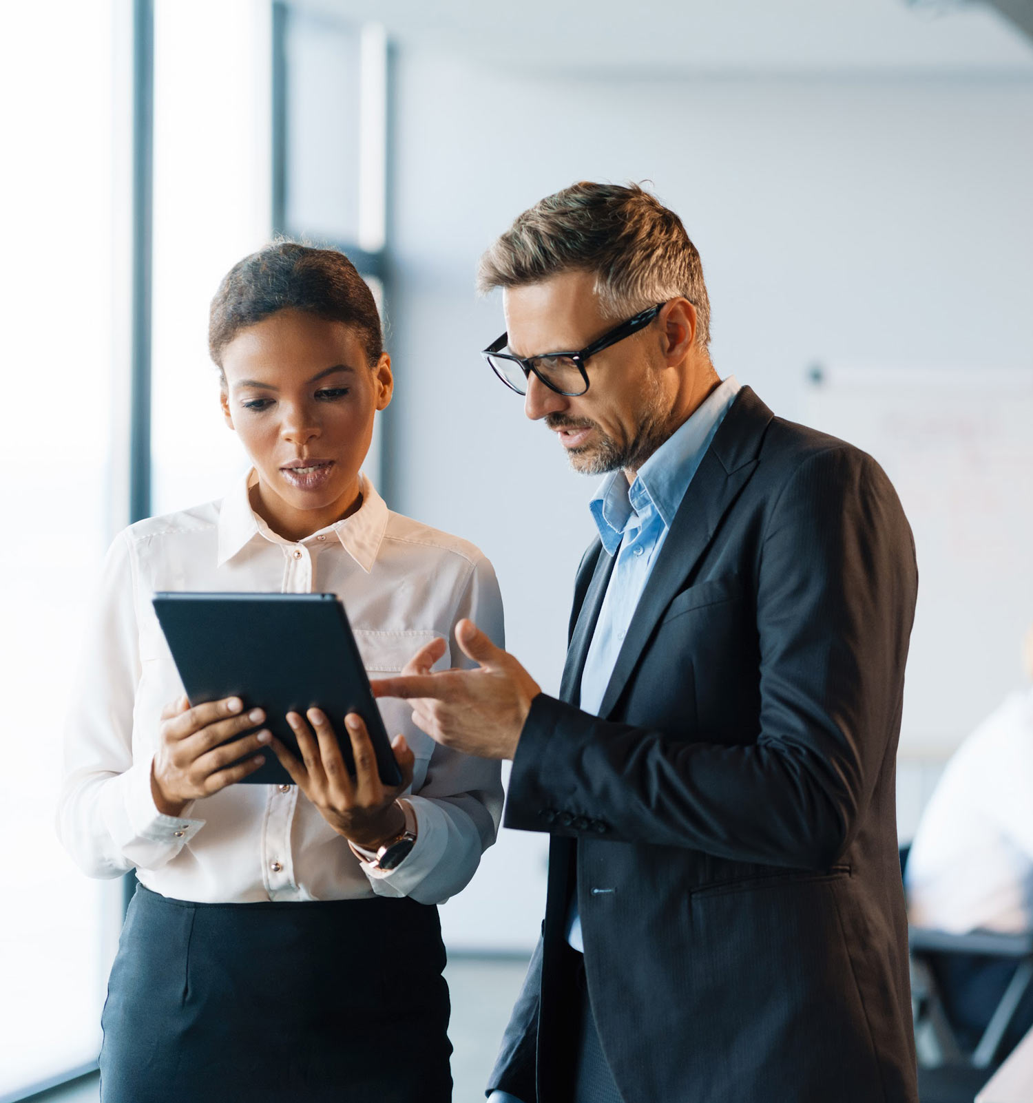 Sales professionals collaborating with the Kinetics platform on a tablet