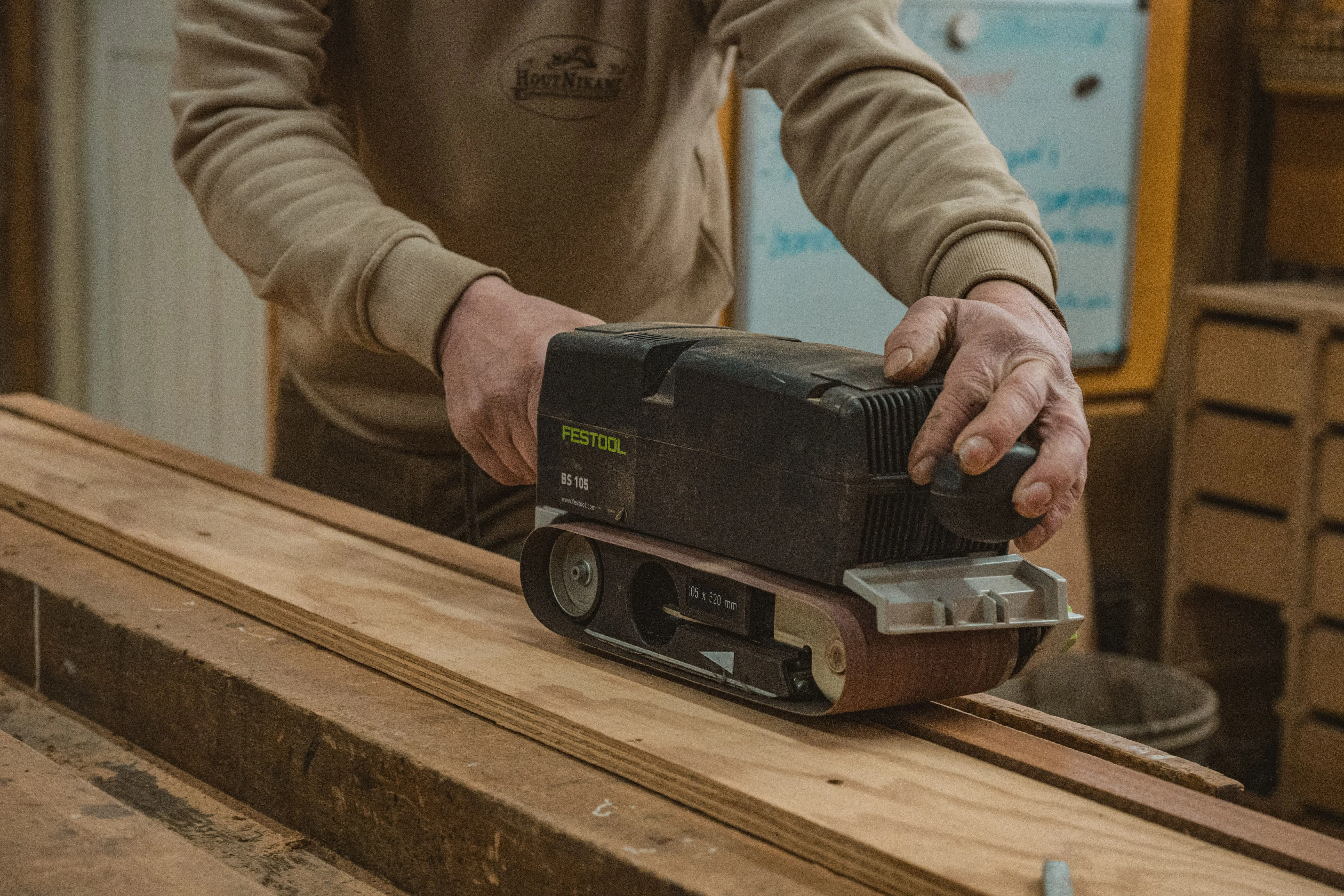Handmatig schuren van hout met een schuurmachine