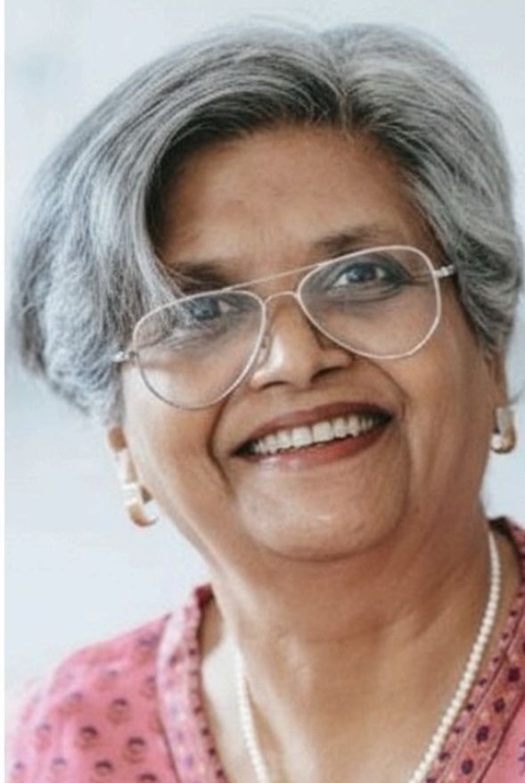 A man sitting on a stool in a black shirt.