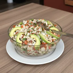 Glass bowl of ceviche with avocado slices, diced tomatoes, onions, and herbs on a white plate with a fork.