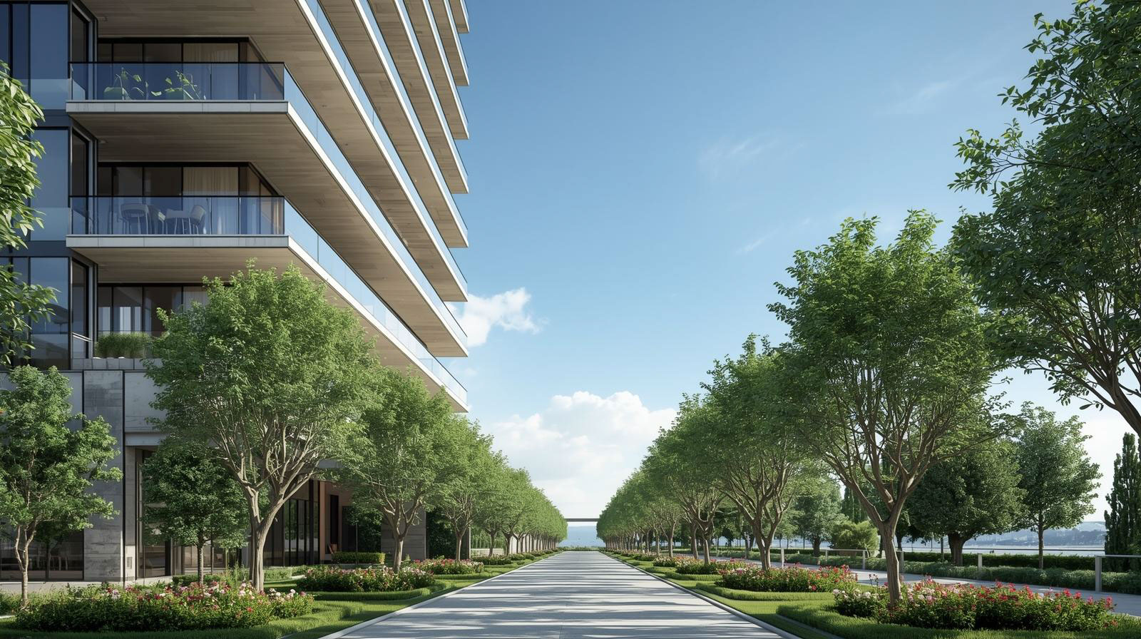 Wide paved pathway flanked by rows of lush green trees and manicured flower beds beside a modern building under a clear blue sky.