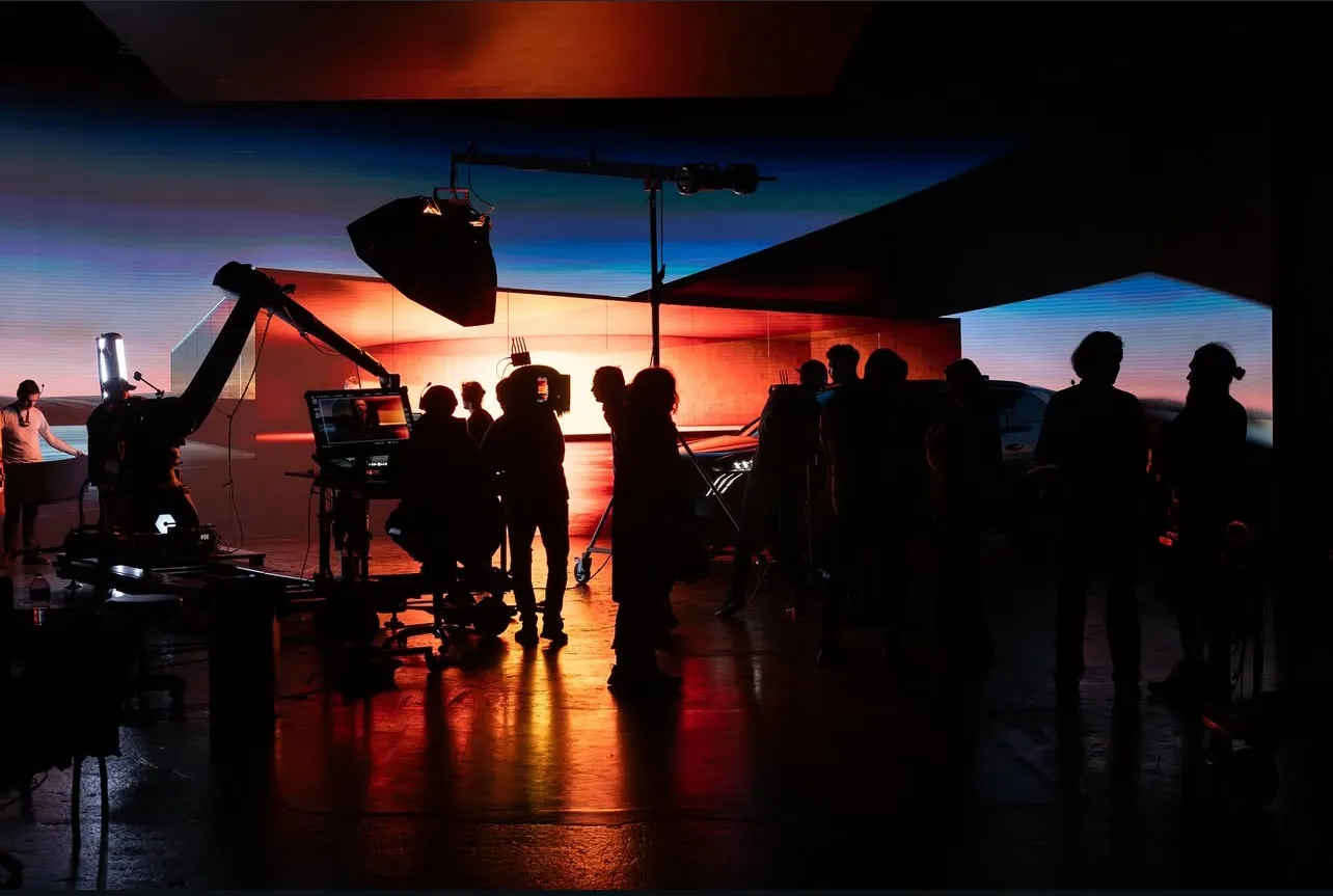 Silhouettes de l'équipe technique ATEMI Productions sur un plateau de tournage en studio