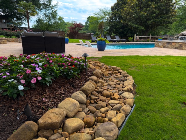 river-rock-flower-bed-border-pool-patio-lounge-sod