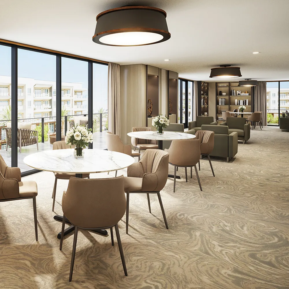 Modern lounge with round tables, beige chairs, sofas, large windows, and floral centerpieces.