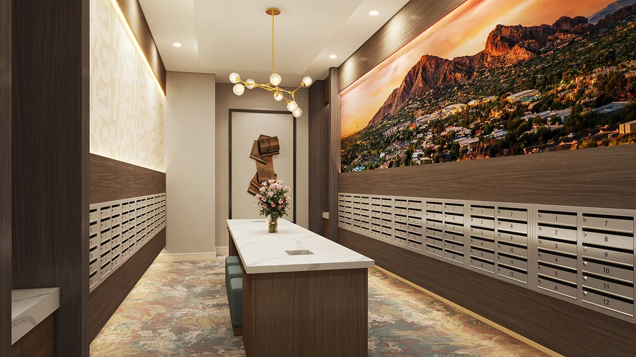 The Monroe mailroom with rows of mailboxes, central table with flowers, abstract wall art, and mountain mural.