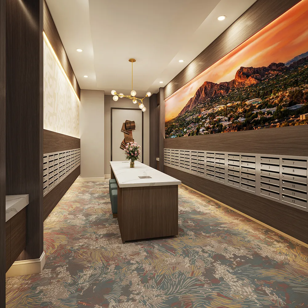 The Monroe mailroom with rows of mailboxes, central table with flowers, abstract wall art, and mountain mural.