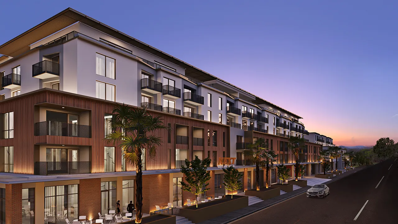 Monroe, a modern multi-story apartment building with balconies and lit palm trees at dusk.