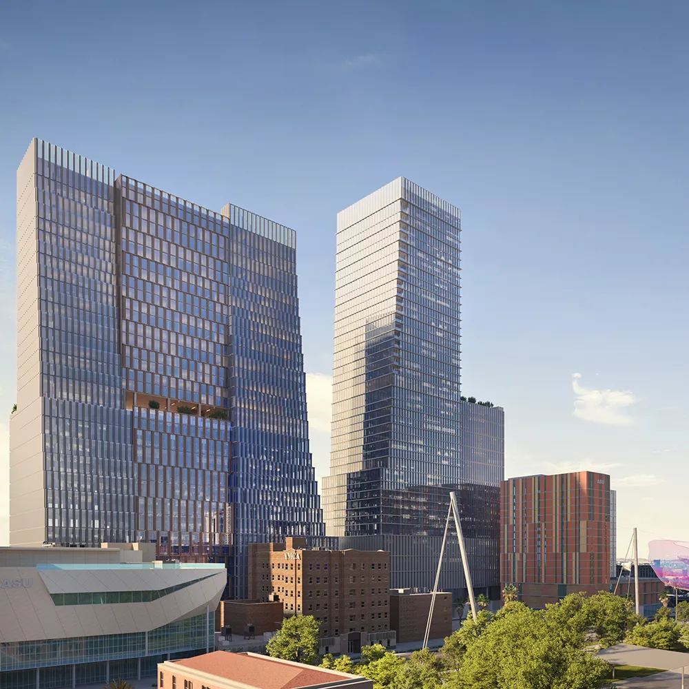 Modern city skyline with tall glass buildings and a clear blue sky during the day.