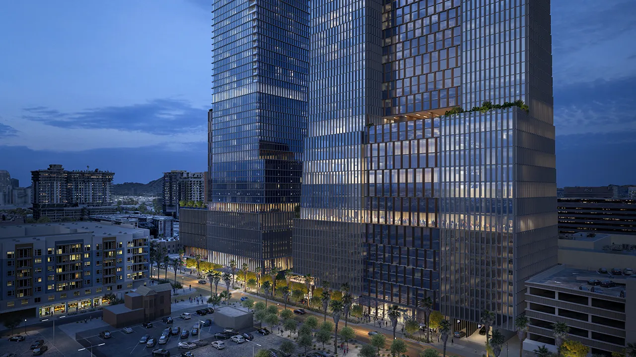 Arro, modern glass skyscrapers at dusk with lit street and parked cars below in downtown Phoenix.