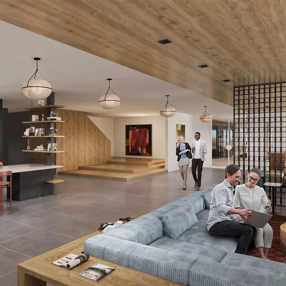 Modern clubhouse interior with two people seated on a couch using a laptop and two others walking and talking.