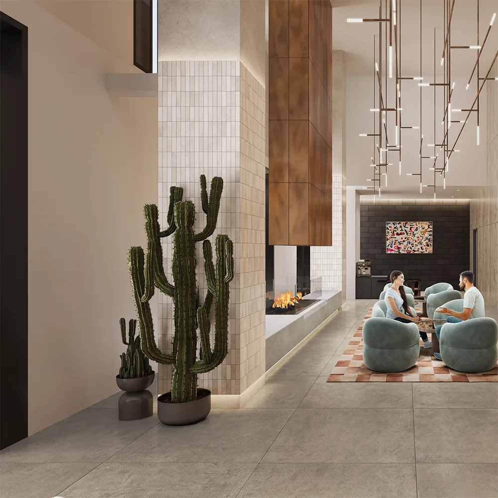 Modern lobby with hanging lights, cactus plants, fireplace, seating area, and two women walking down stairs.