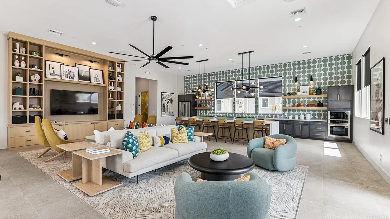 Modern lounge area and kitchen with mustard chairs, patterned pillows, island, and green geometric wallpaper.