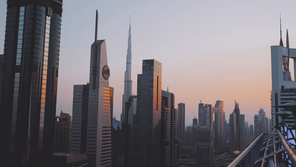 City skyline featuring tall modern skyscrapers at sunset, with the Burj Khalifa prominently in the center.