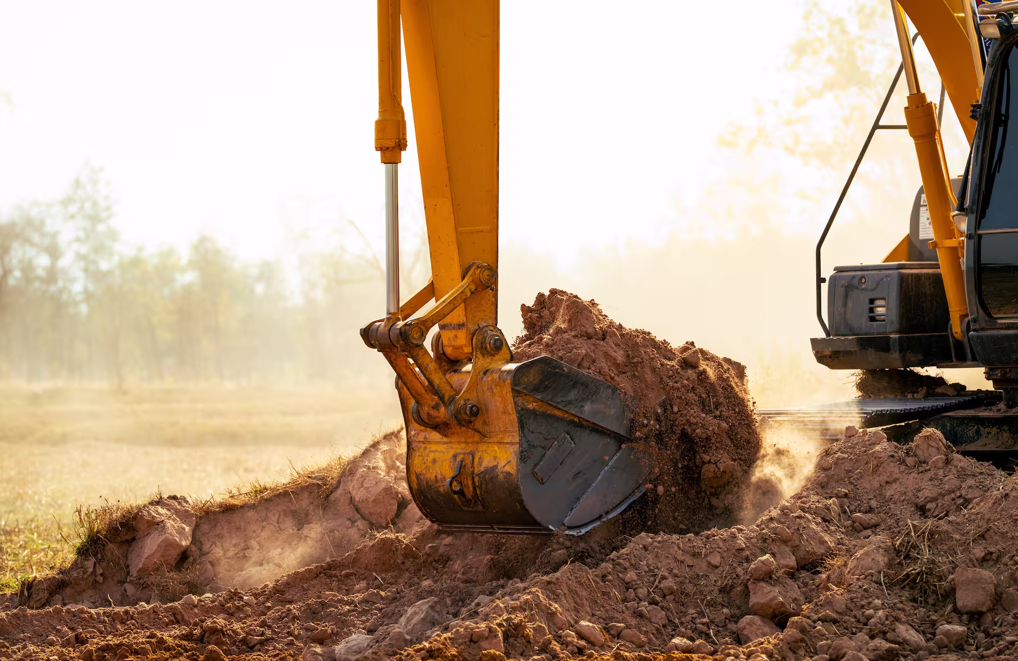 Backhoe working by digging soil at construction site