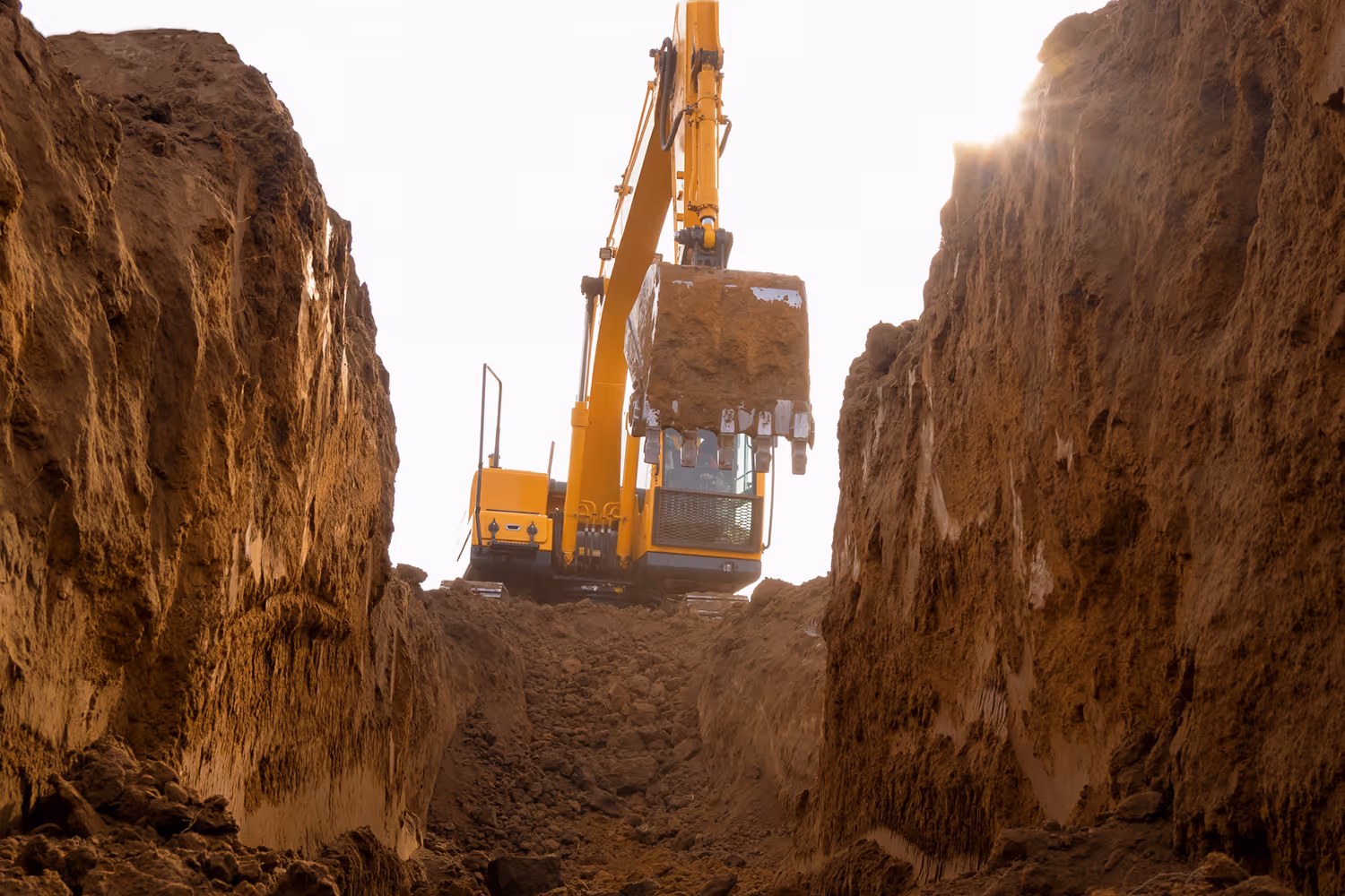 Excavator above a trench