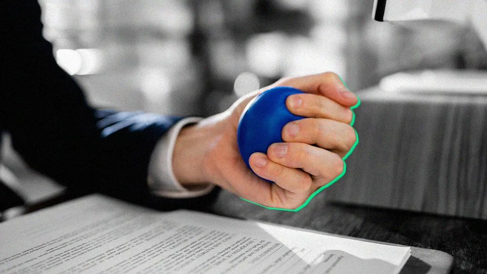 hand of office worker squeezing stress ball
