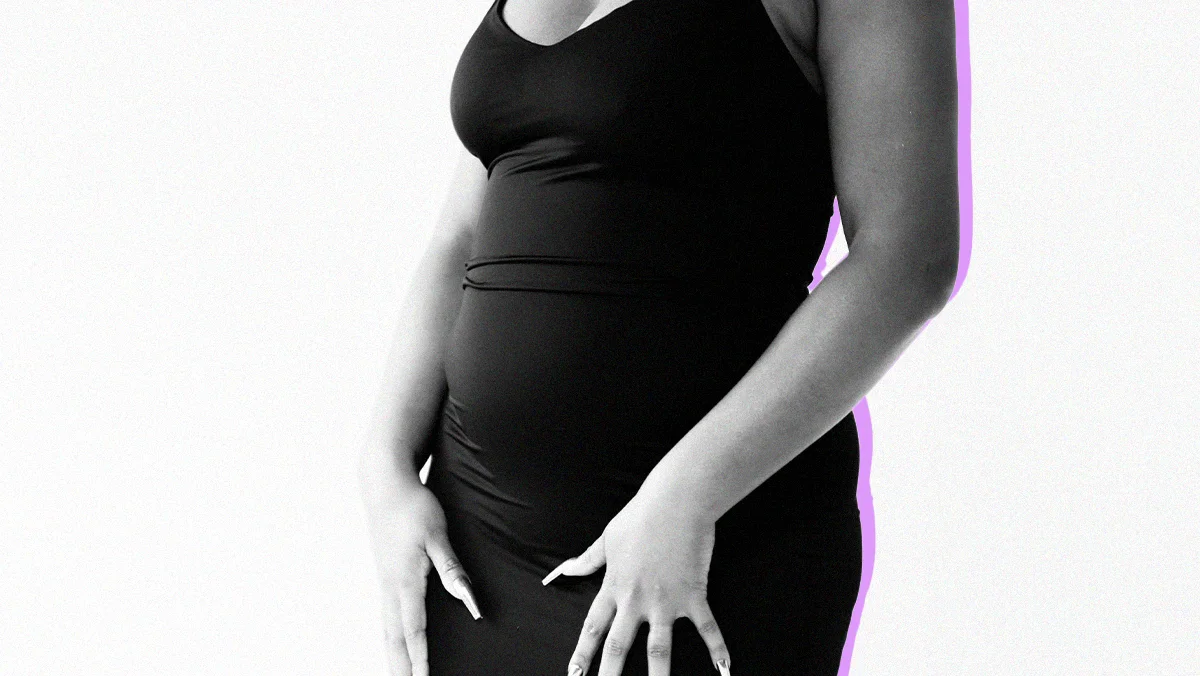 woman with great nails in a tight-fitting outfit, showing early stages of pregnancy