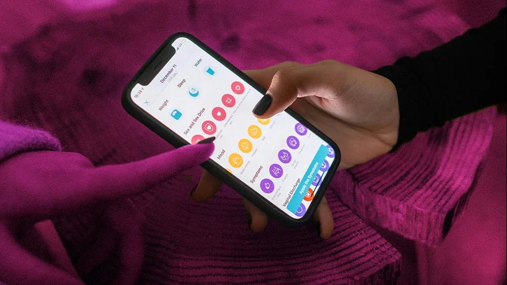 wellness app on a phone with two hands interacting with it