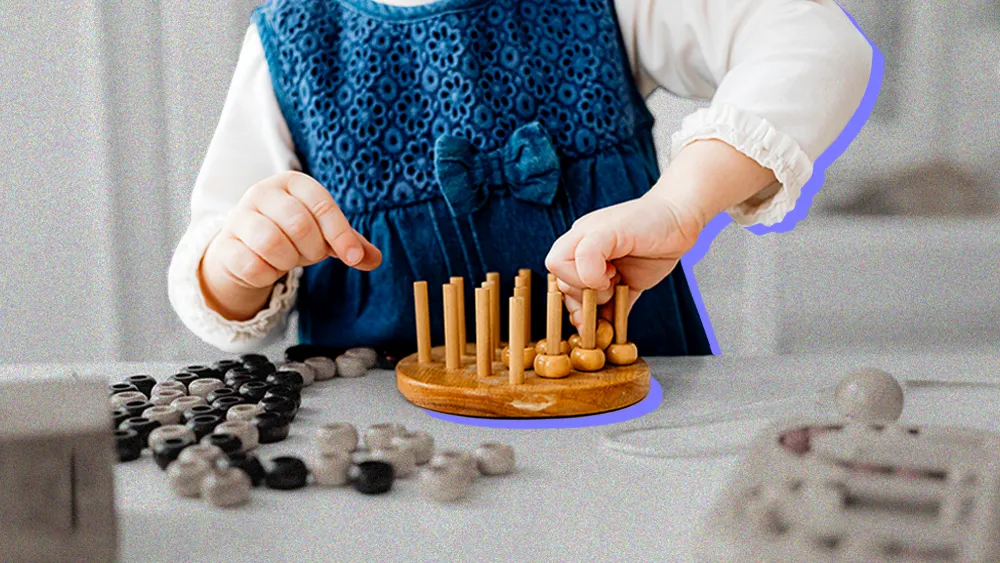 child playing with a wooden logic puzzle