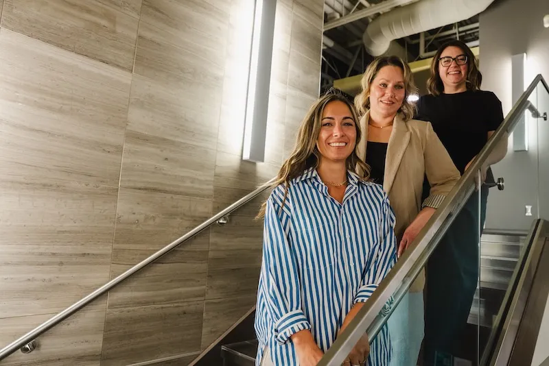 Jessica, Carly, and Meaghan, standing in a stairwell