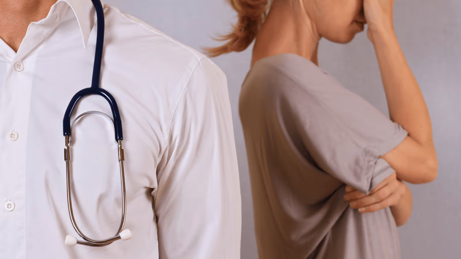 mournful woman at rear with doctor in foreground. faces hidden.