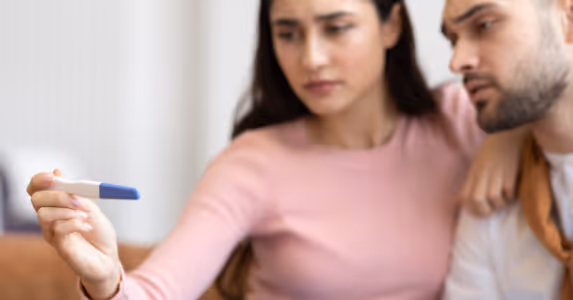 30-something couple looking at the results of a pregnancy test