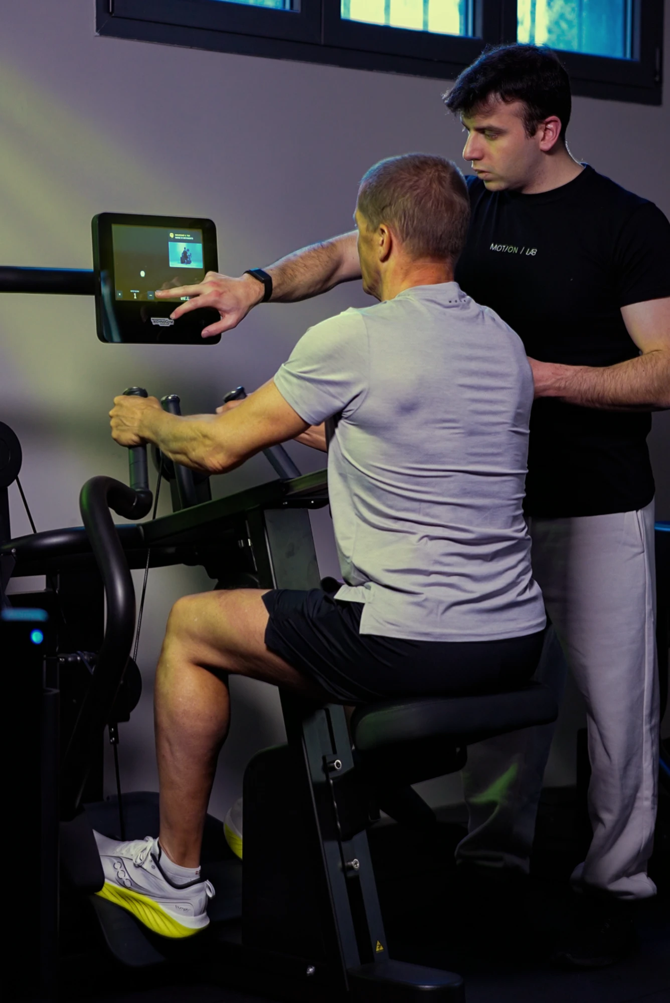 Un trainer MotionLab segue un cliente durante un esercizio su Technogym Biostrength