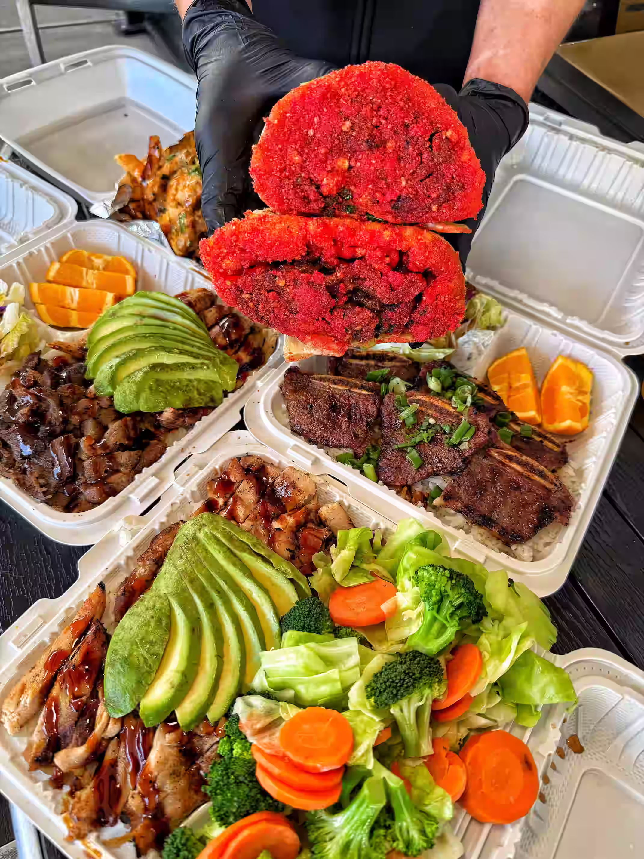 Three plates of hawaiian bbq with various protein options and sides of steamed vegetables and avocado.