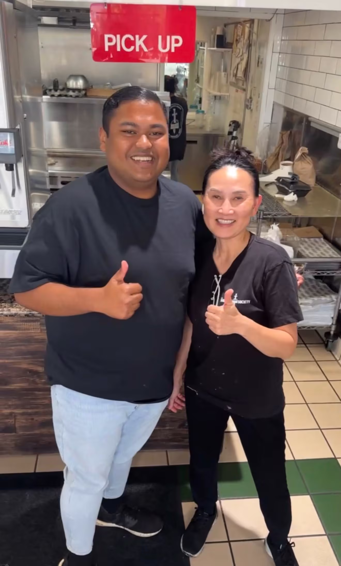 Obi smiling and giving a thumbs up with the owner of The Sandwich Society in Tustin.