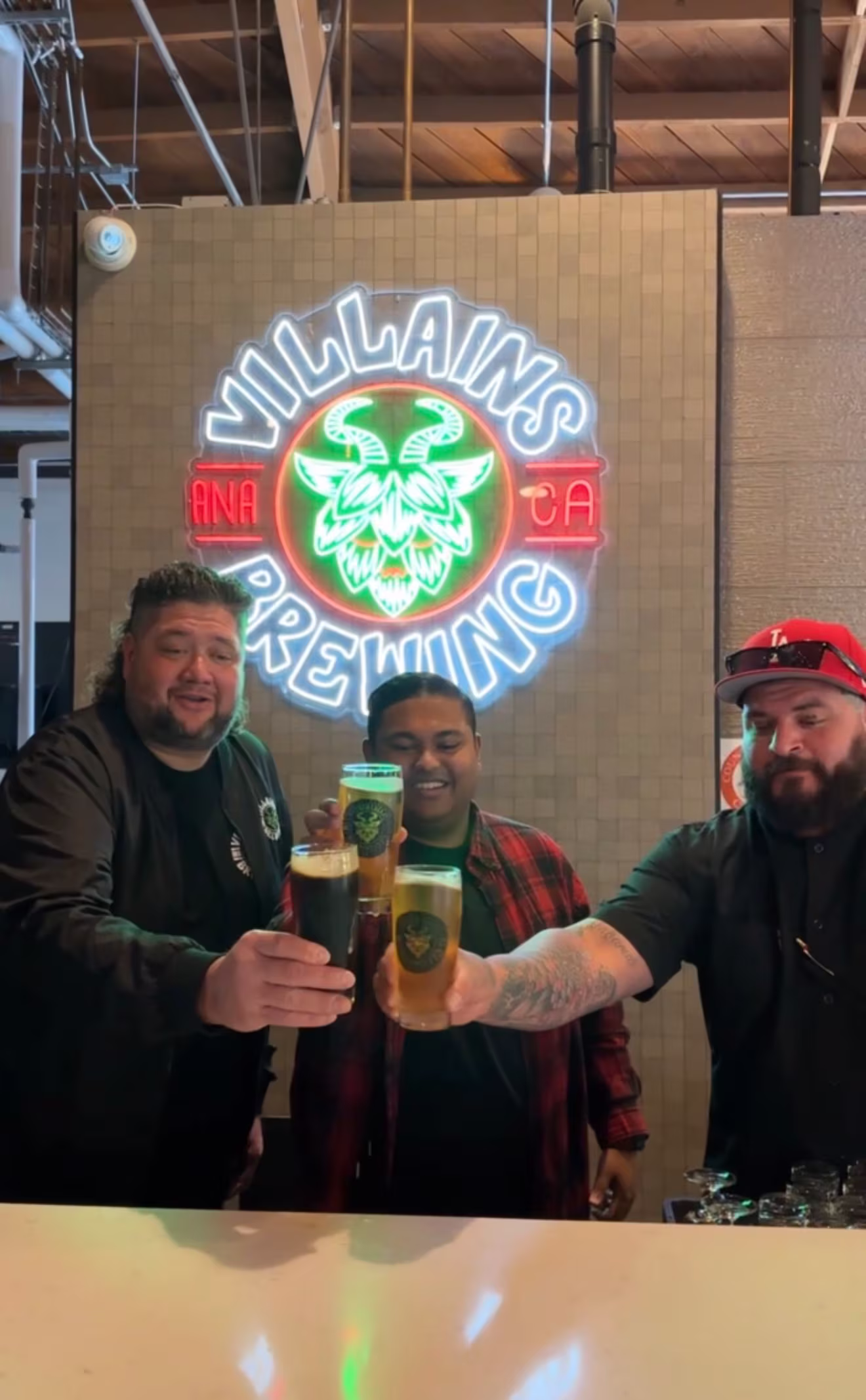 Obi and owners of Villains Brewing in Anaheim cheers their beer glasses.
