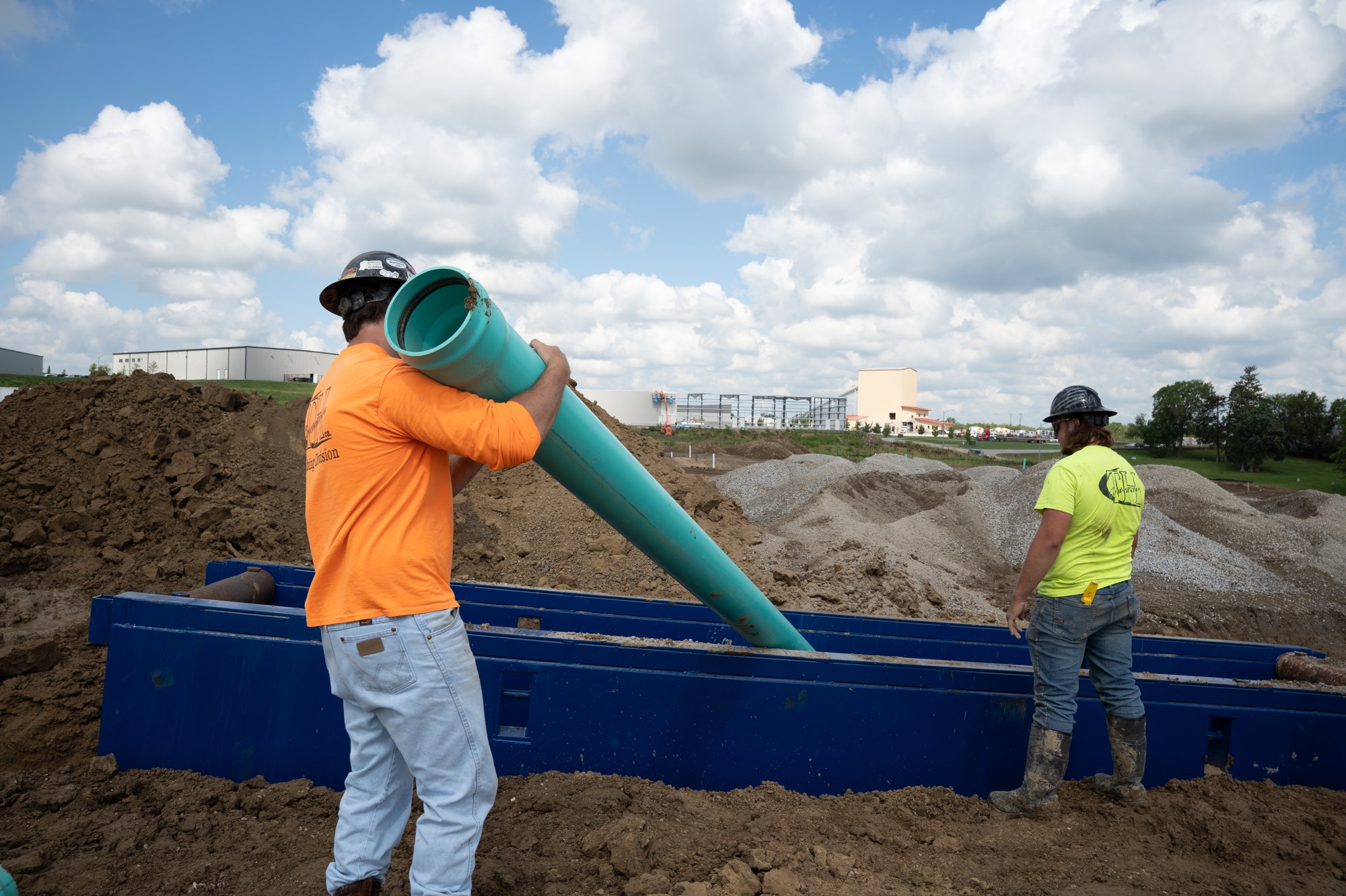 Plumbing crew placing pipe on site