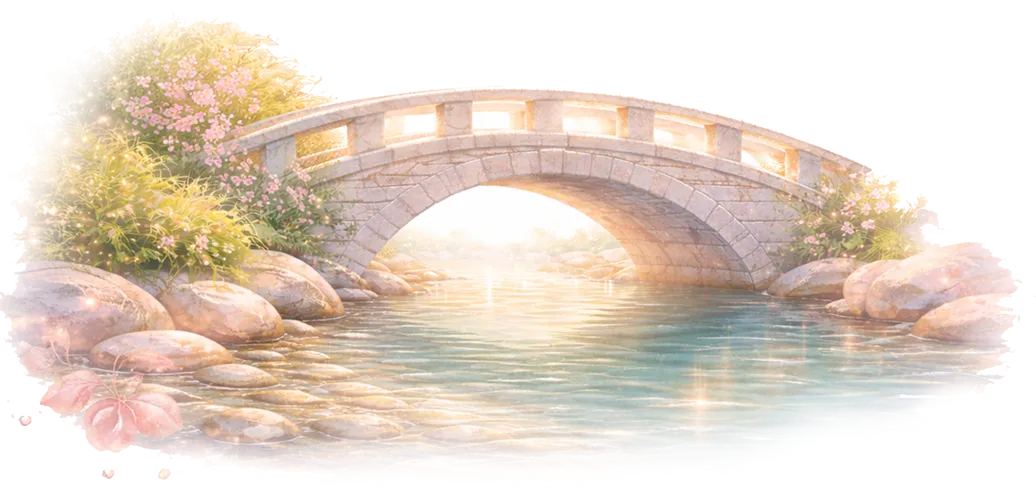 Stone arch bridge over a calm river with sunlight reflecting on the water and flowering bushes on the riverbank.