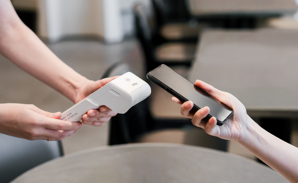 Customer paying with a phone on a handheld KPay terminal