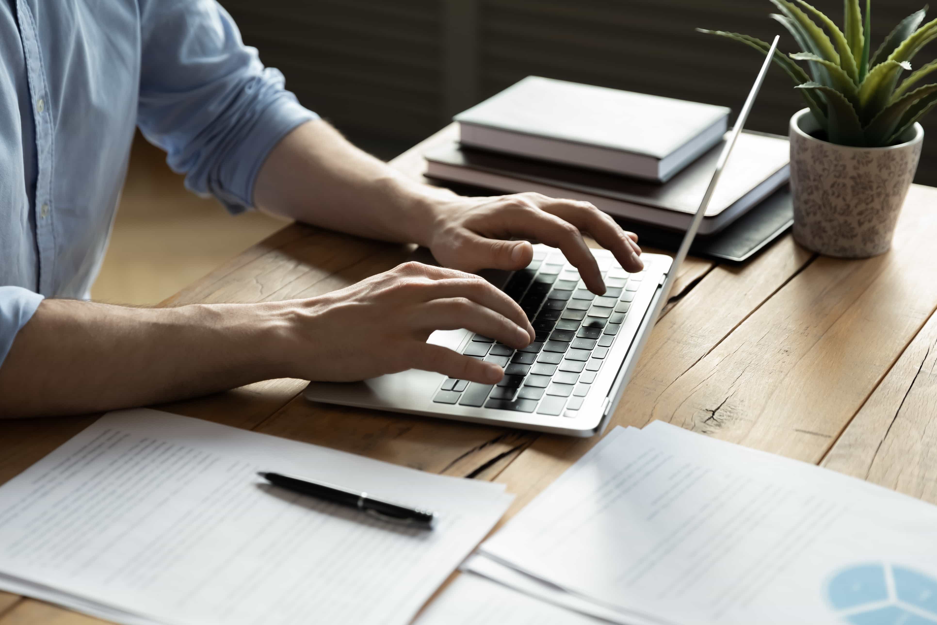 man typing on laptop to apply for alipay hk merchant account
