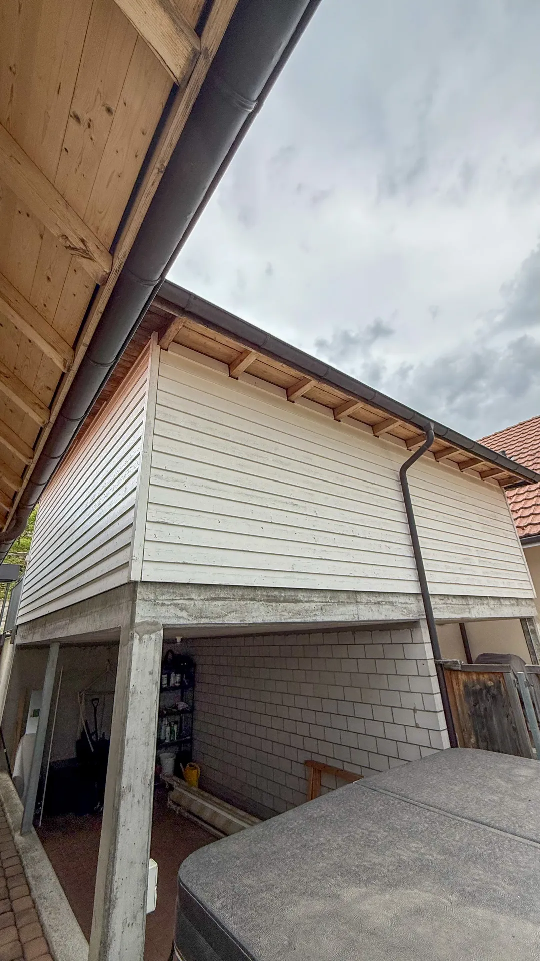 Leerer Raum mit dunkelblauen Wänden und Tür sowie Betonboden und weißer Decke.