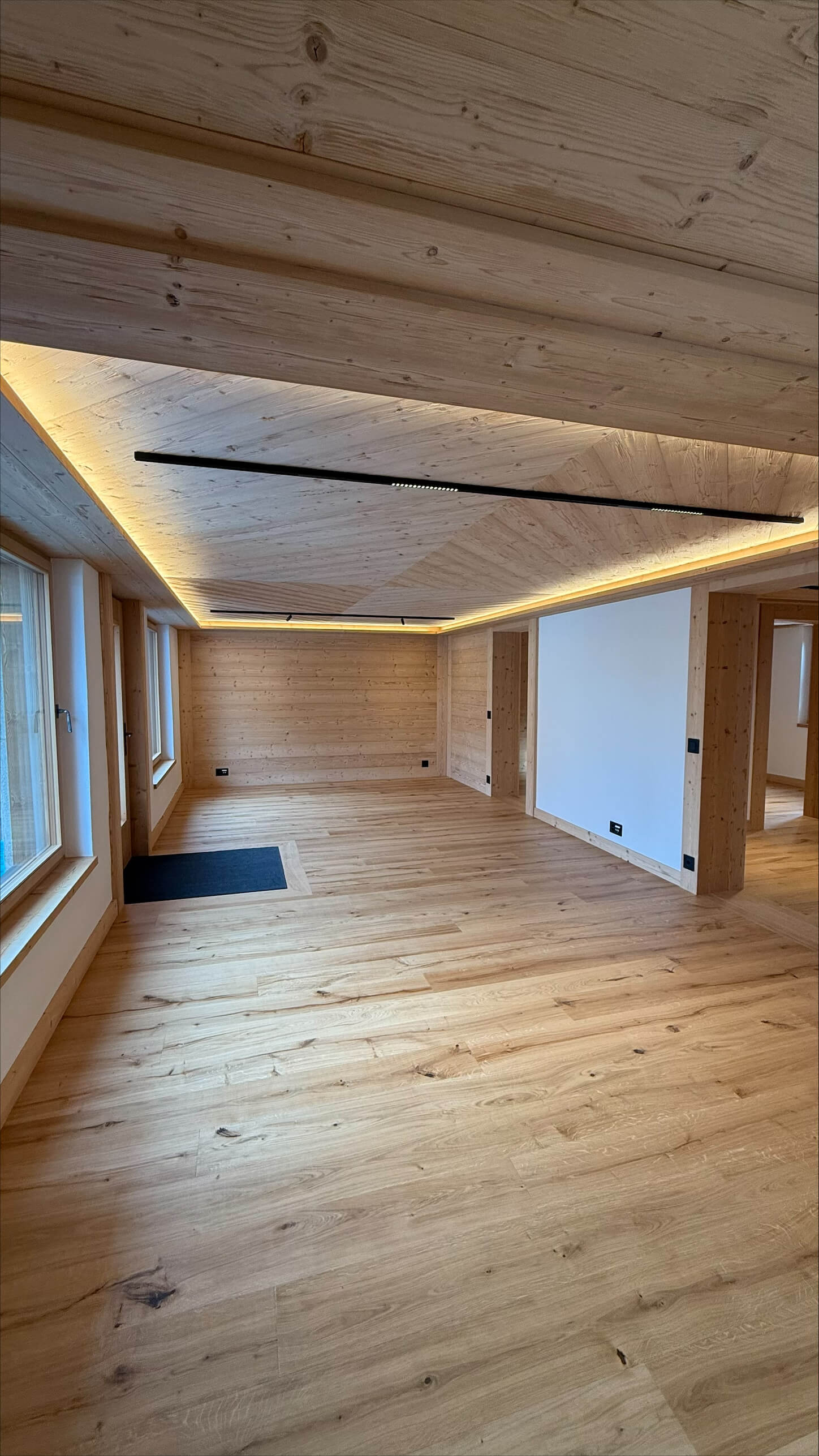 Kleines Geschäft mit hellblauem Tür- und Fensterrahmen an einer Kopfsteinpflasterstraße, darüber bunte Wimpel und Blumenkästen an einem Balkon.