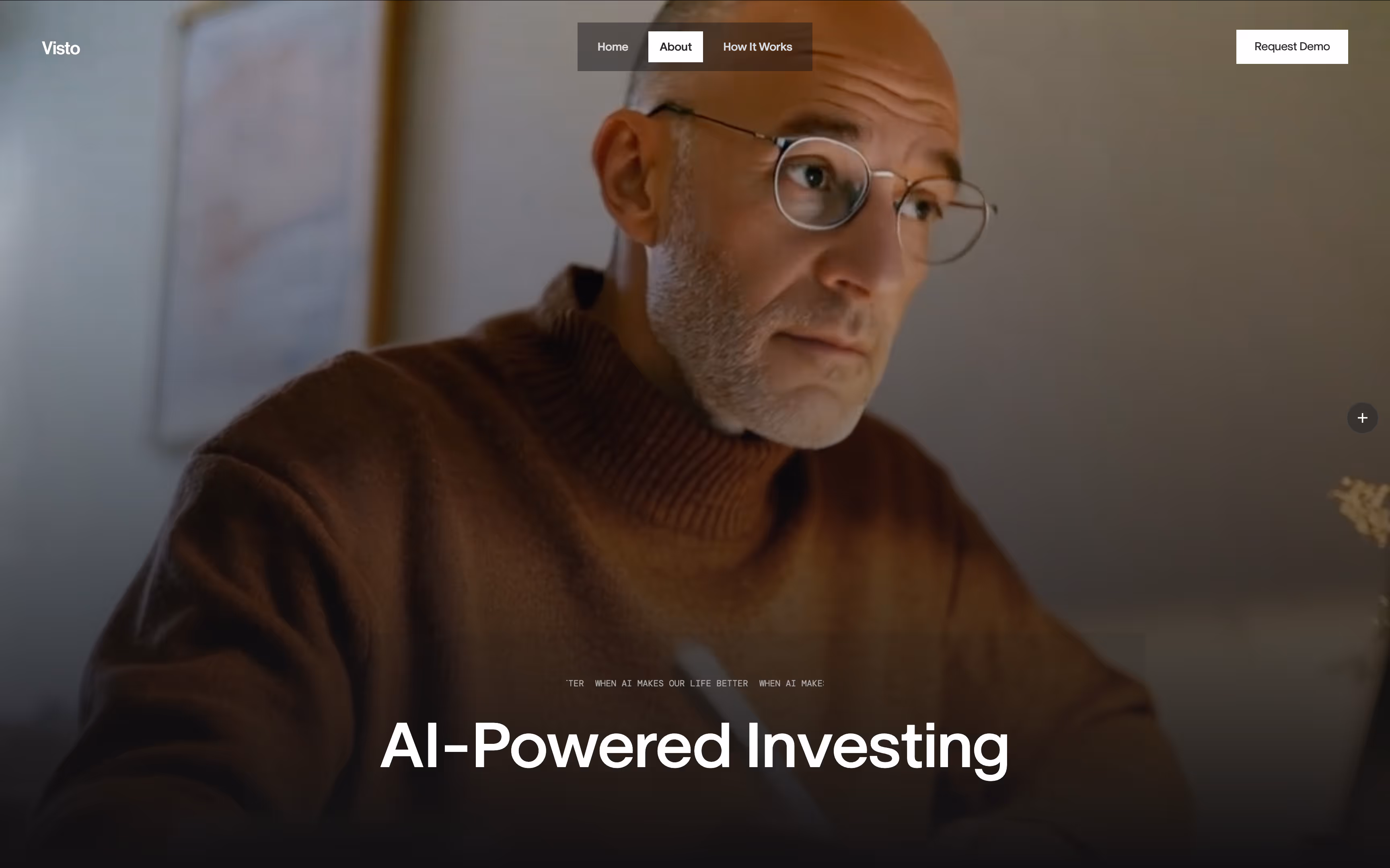 Man with glasses and a brown sweater looking thoughtfully to the side in a softly lit room.
