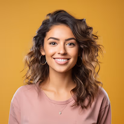 Smiling woman with curly brown hair wearing hoop earrings and a pink shirt against a yellow background.