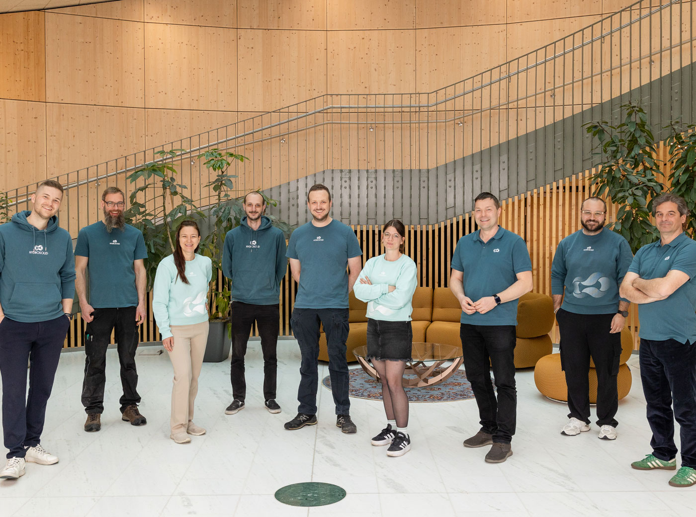 HydroSolid Team in mitten einer runden Aula